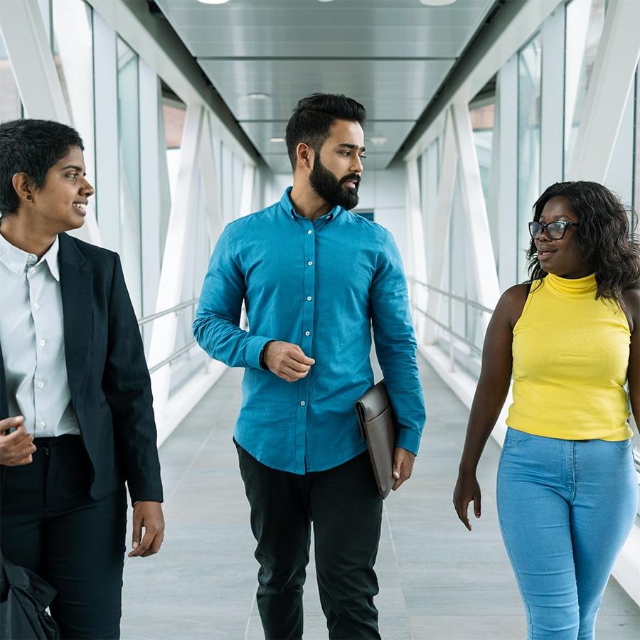 three students walking in catwalk, tallest in center